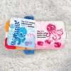 BABY EINSTEIN Puha könyv rágókával és textúrákkal Shades of the Sea™, 0m+