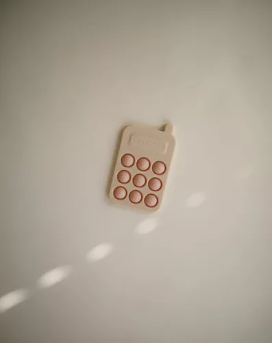 Mushie Pukkasztós játék - telefon - púderrózsaszín